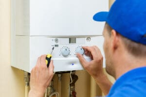 plumber setting up a central gas heating boiler at home