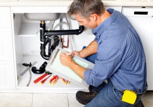 Plumber repairing a sink drain in a Houston home